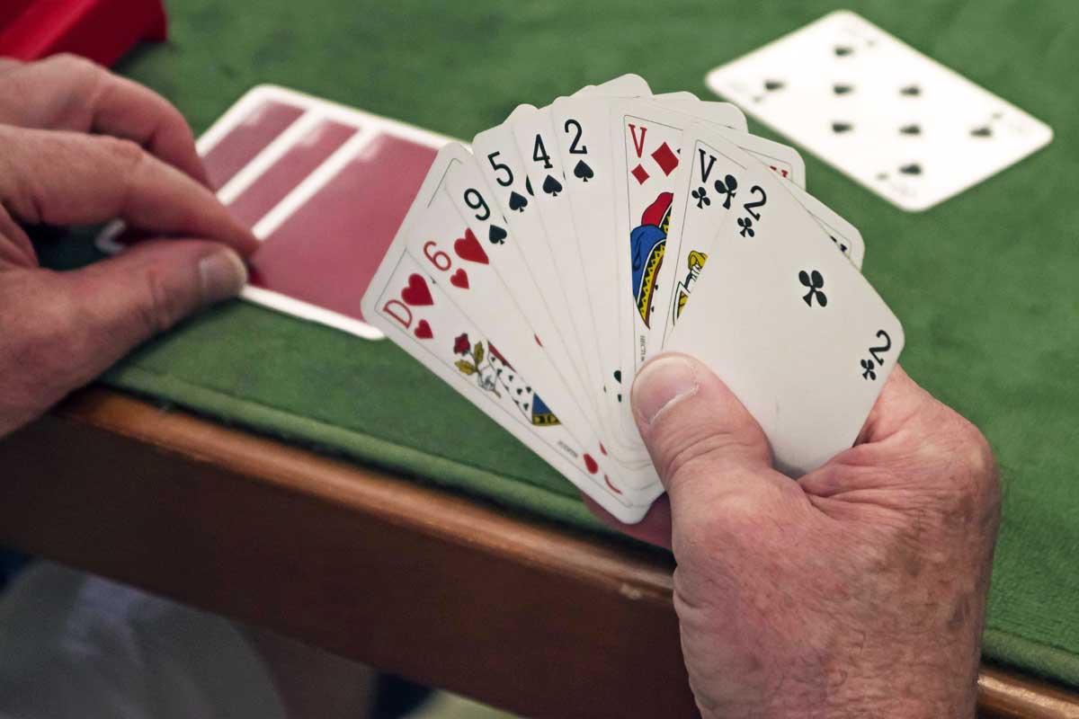 Gros plan sur les mains d'un joueur de Belote