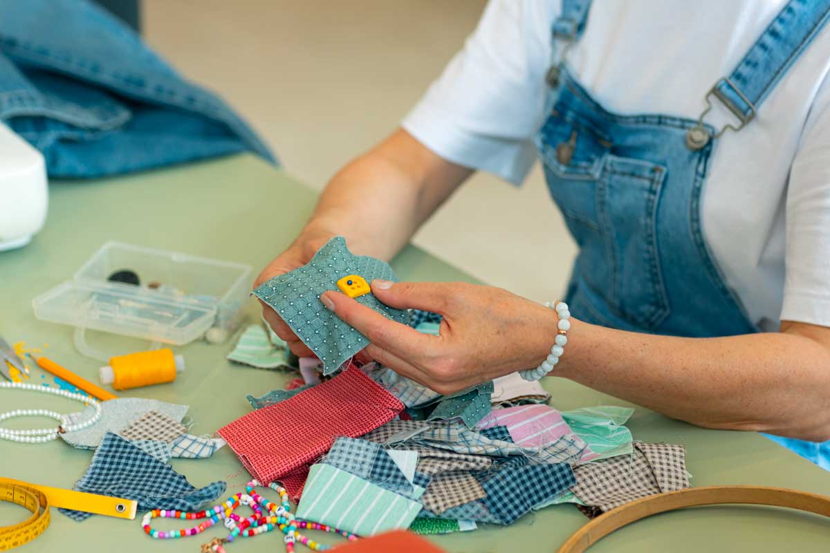 Une personne choisit des bouts de tissu pour faire un patchwork
